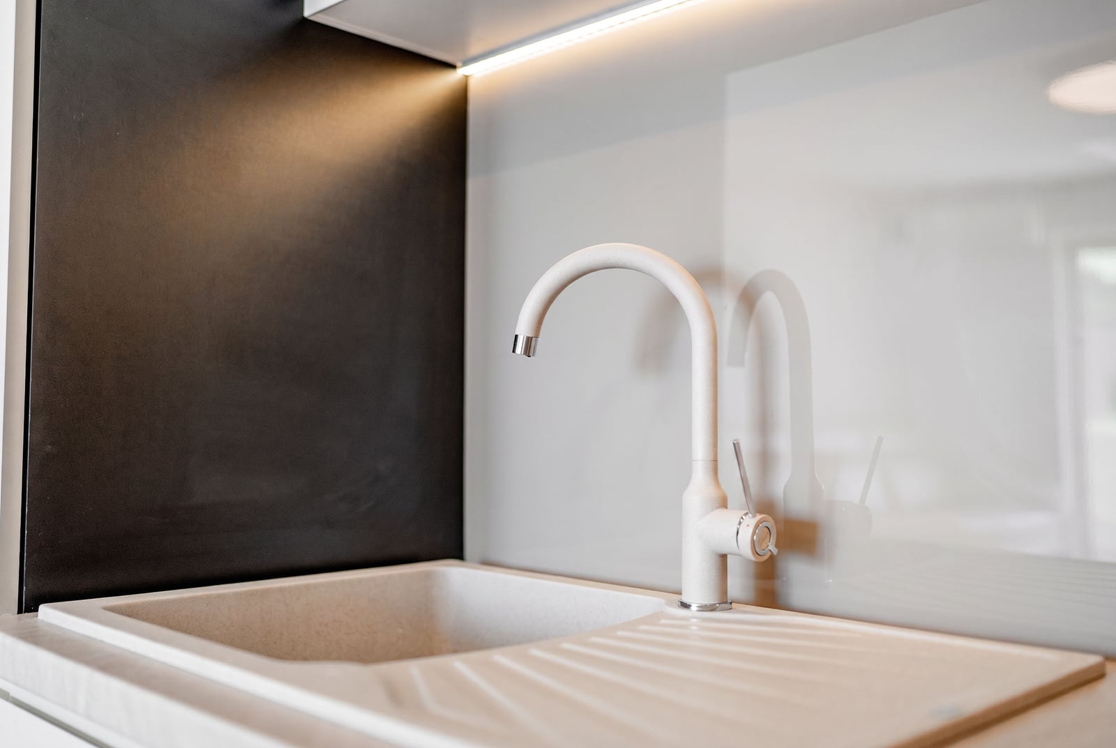 Modern kitchen in an apartment in Sveti Stefan, Montenegro: light stone sink and a stylish faucet with lighting.