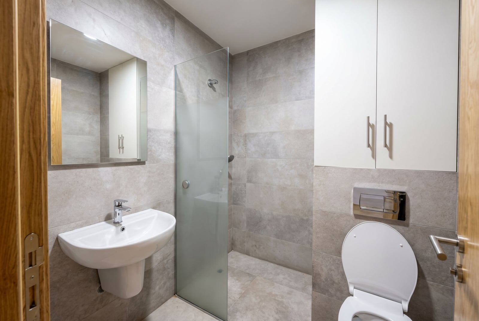 Modernes Badezimmer mit Duschkabine in einer Wohnung in Bečići, Montenegro: Fliesen, Sanitäranlagen und Möbel.