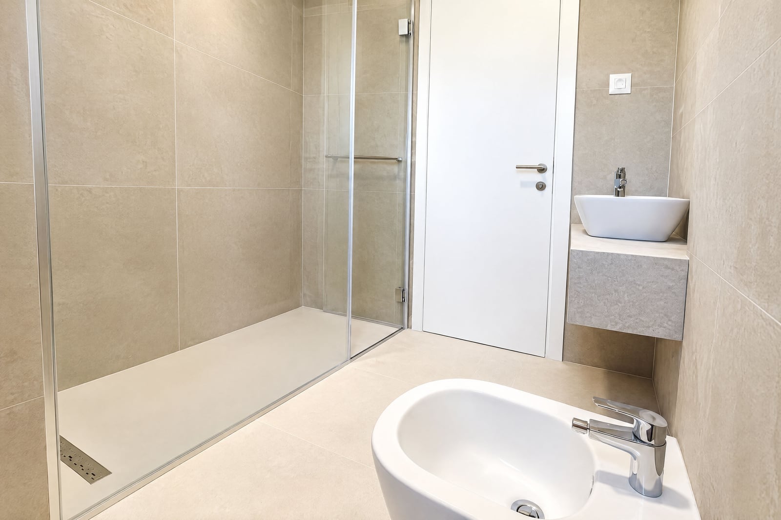 Modern bathroom with a shower cabin and beige tiles in an apartment in Becici, Montenegro