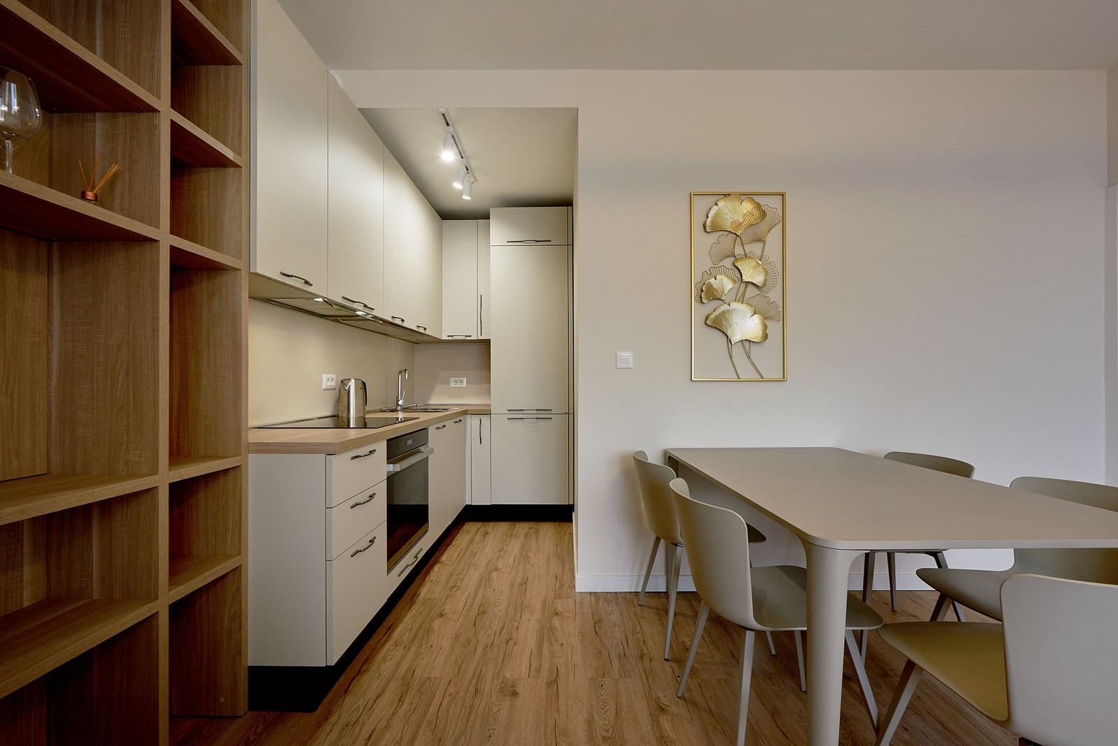 Modern kitchen in an apartment in Bečići, Montenegro: light-colored kitchen set, dining area, and interior decor.