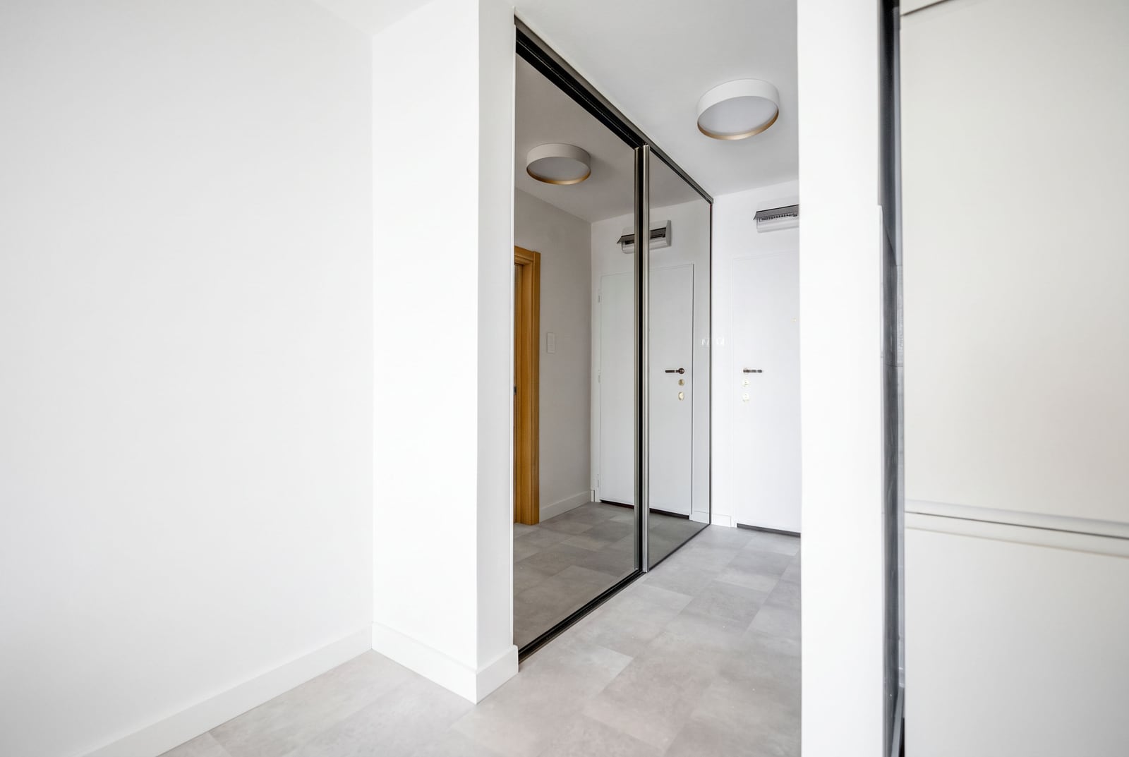 Bright hallway with a mirrored wardrobe in a modern apartment in Sveti Stefan, Montenegro. Minimalist interior.