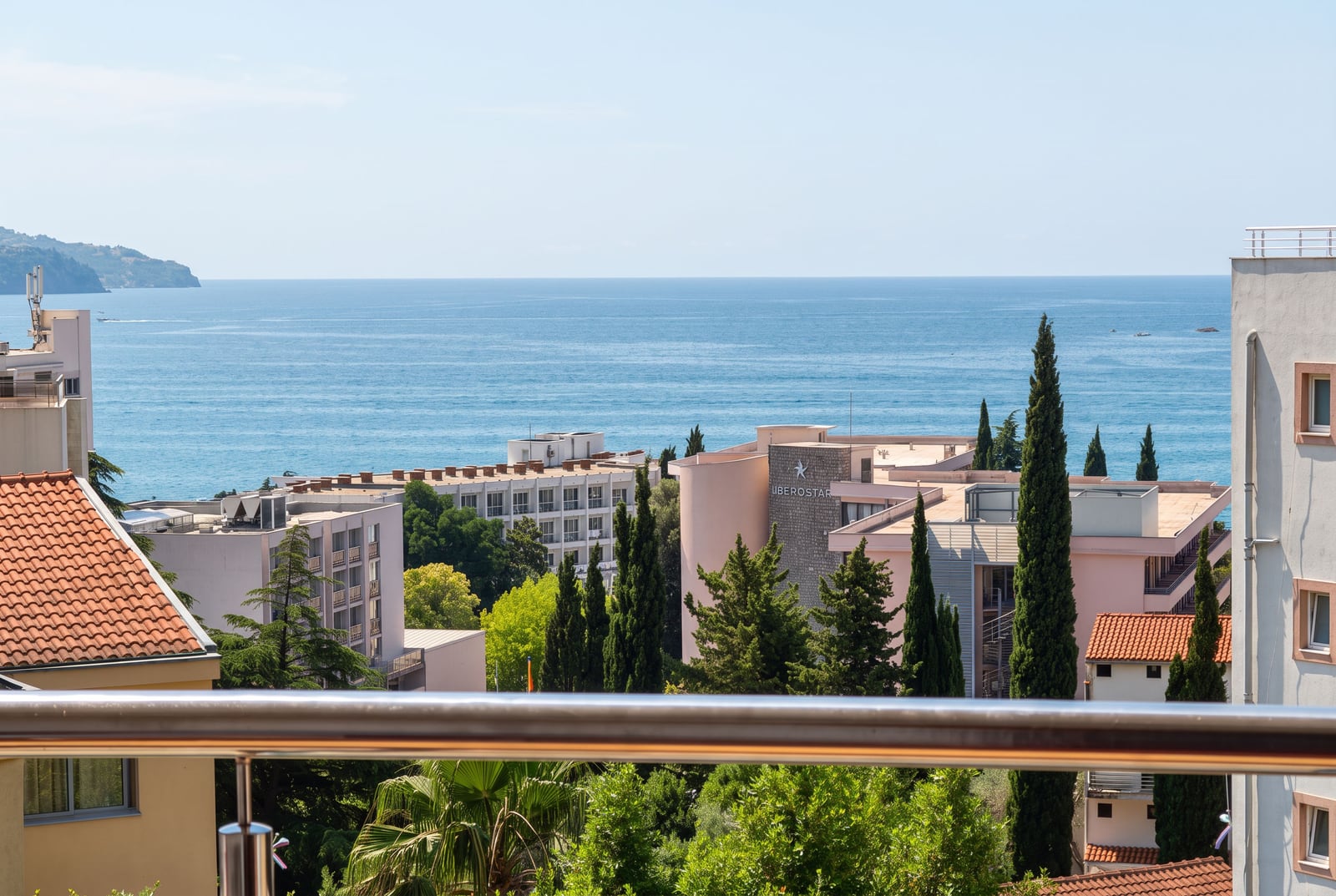 Panoramic view of the Adriatic Sea and cypress trees from the balcony of an apartment in Becici, Montenegro