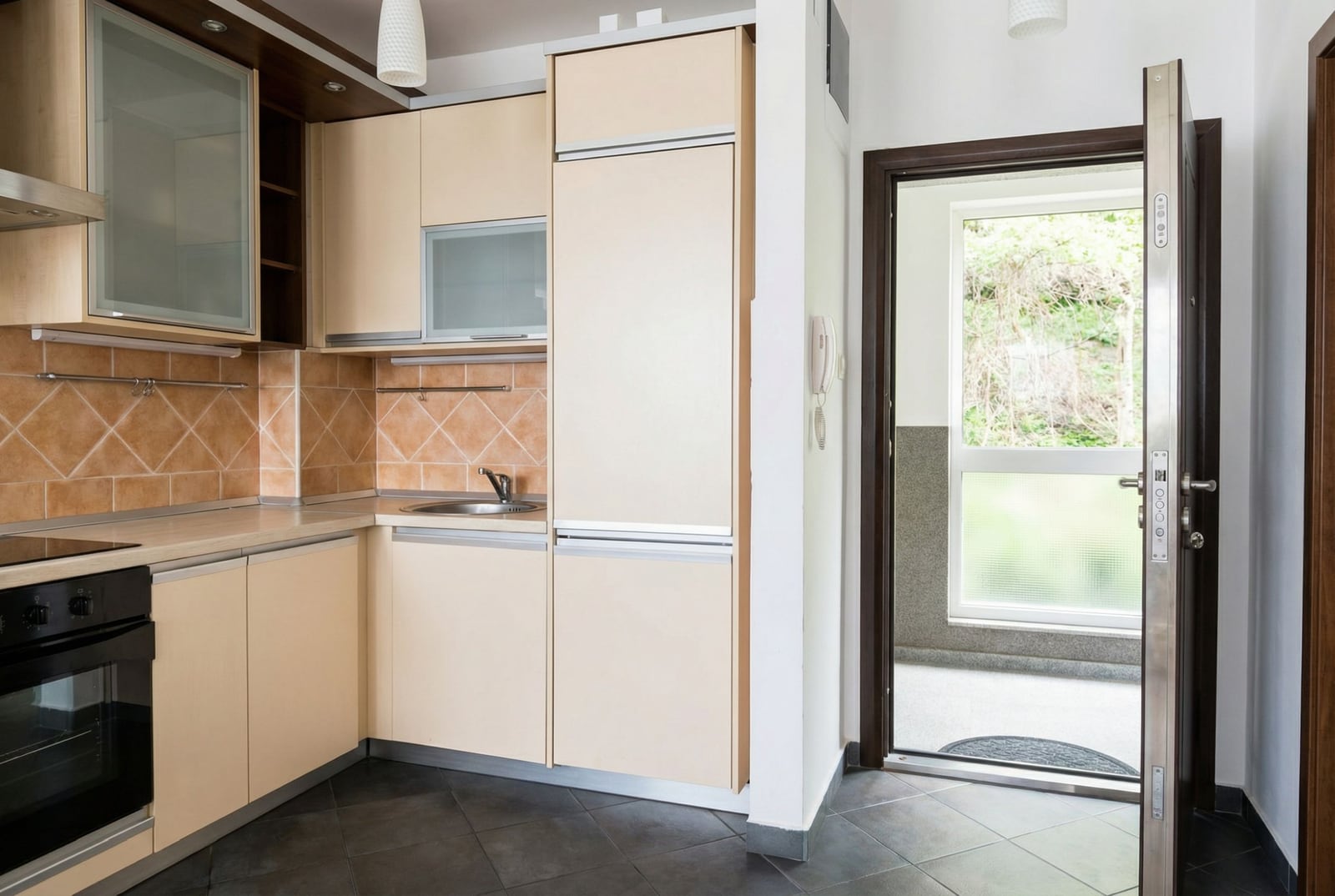 Moderne Küche in einer Wohnung in Petrovac, Montenegro: helle Einbauküche, integrierte Geräte und Zugang zur Terrasse.