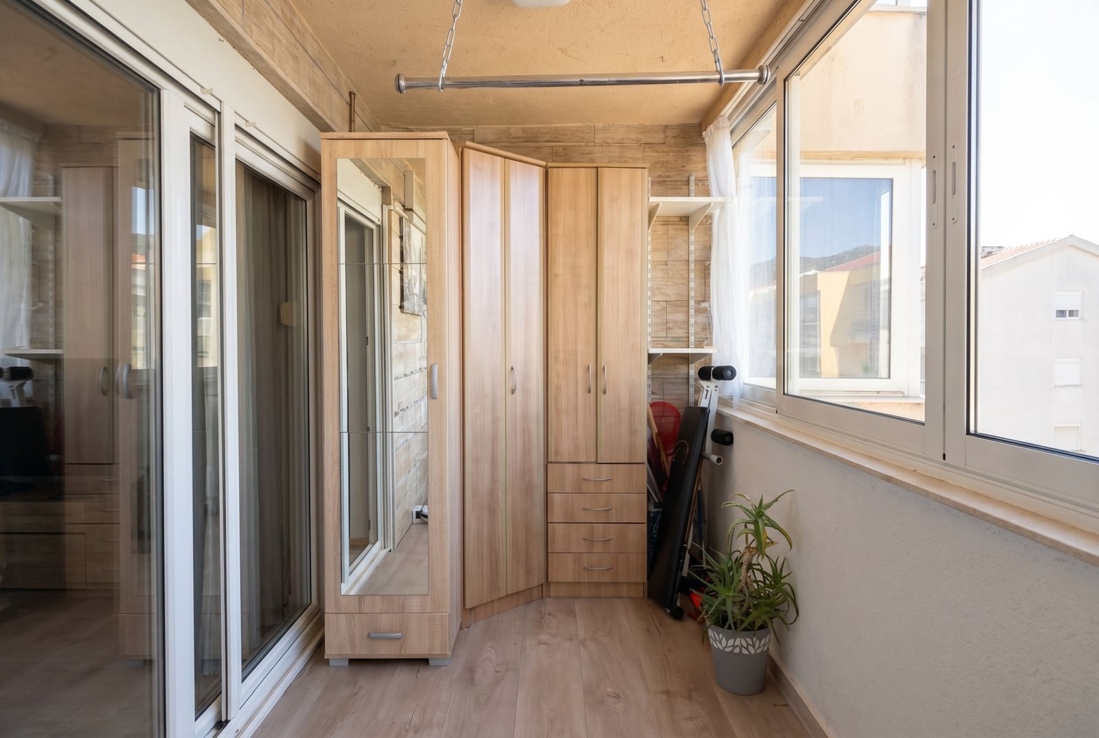 Glazed balcony with a corner wardrobe and panoramic windows in an apartment, Budva, Montenegro.