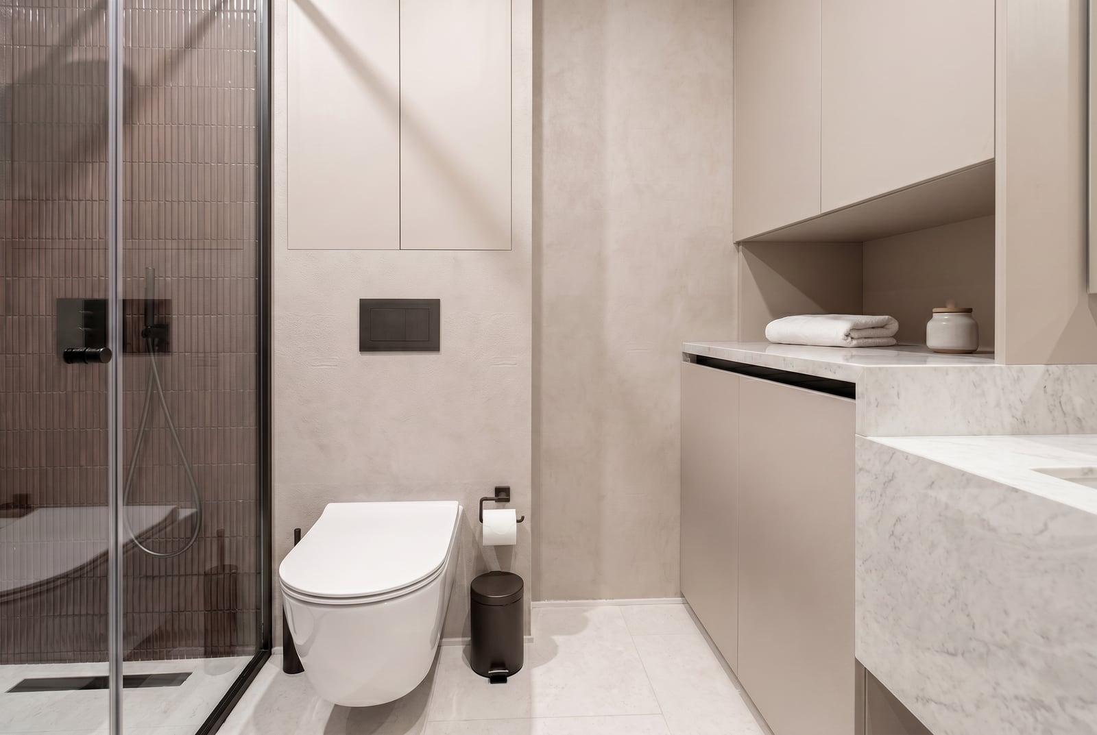 Modernes Badezimmer in einer Wohnung in Tivat, Montenegro: Duschkabine, Marmorarbeitsplatte und stilvolle Möbel.