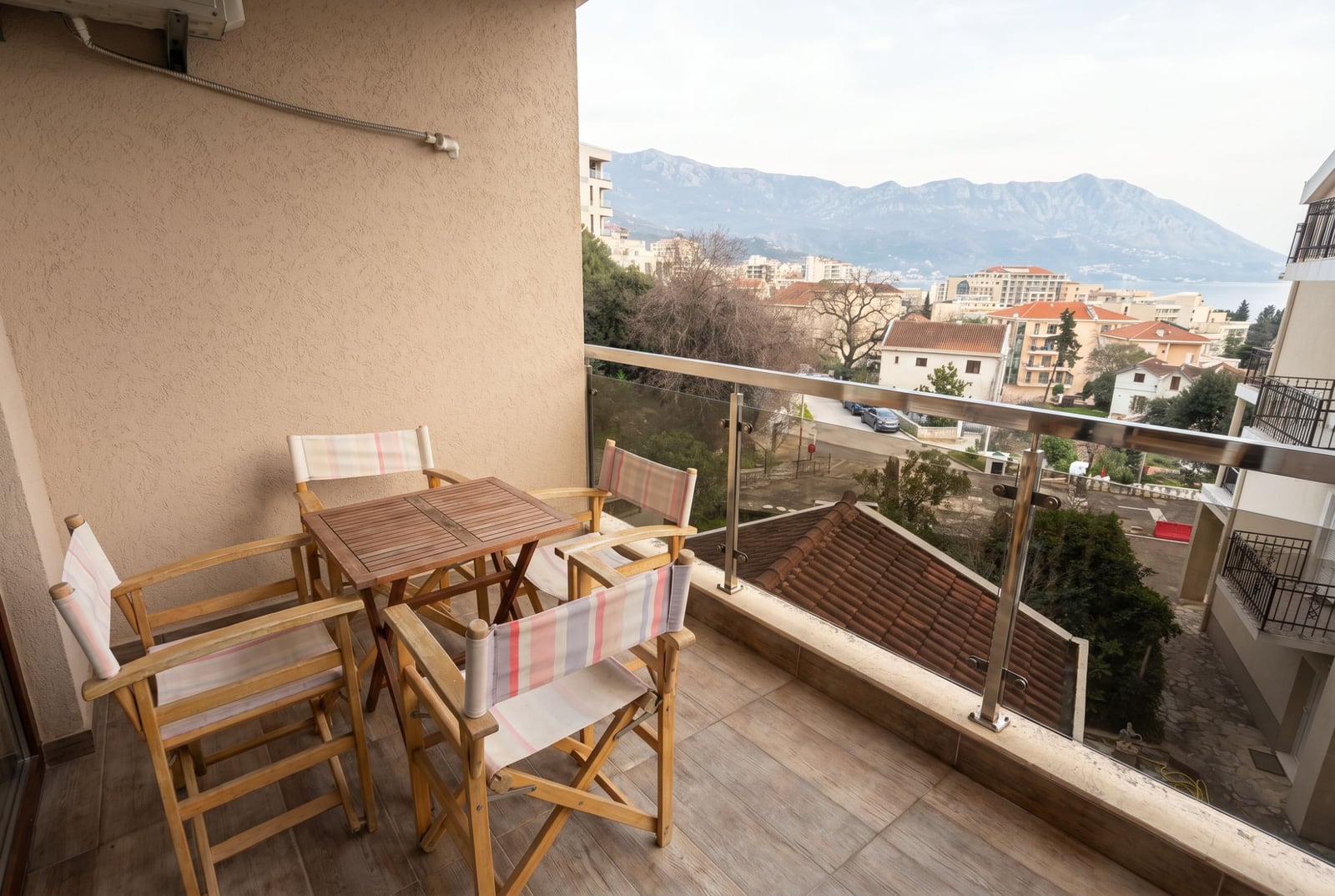 Ahşap mobilyalı ve dağlar ile denize panoramik manzaralı balkon, Bečići, Budva, Karadağ.