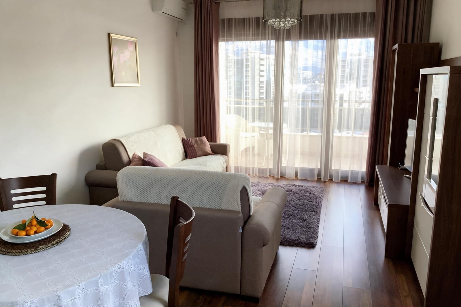Cozy living room with a sofa, furniture, and a panoramic window in an apartment in Budva, Montenegro
