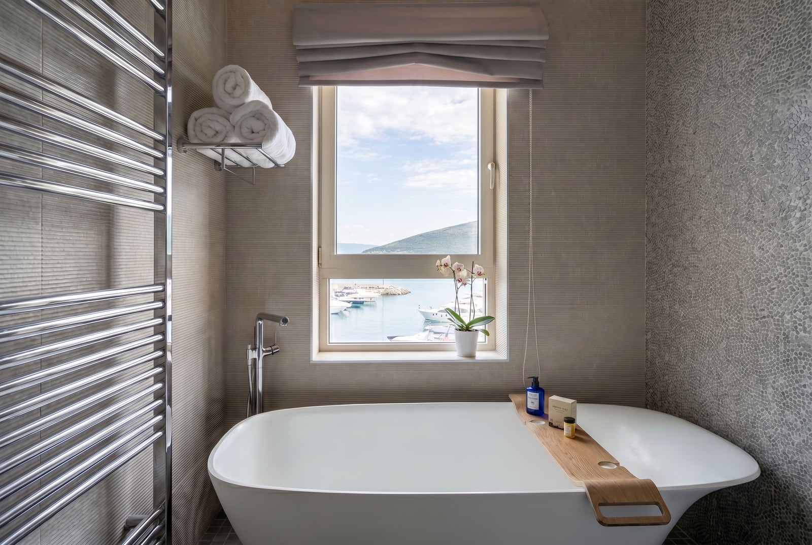 Modernes Badezimmer mit Blick auf den Yachthafen in Luštica, Montenegro: freistehende Badewanne und stilvolle Ausstattung.