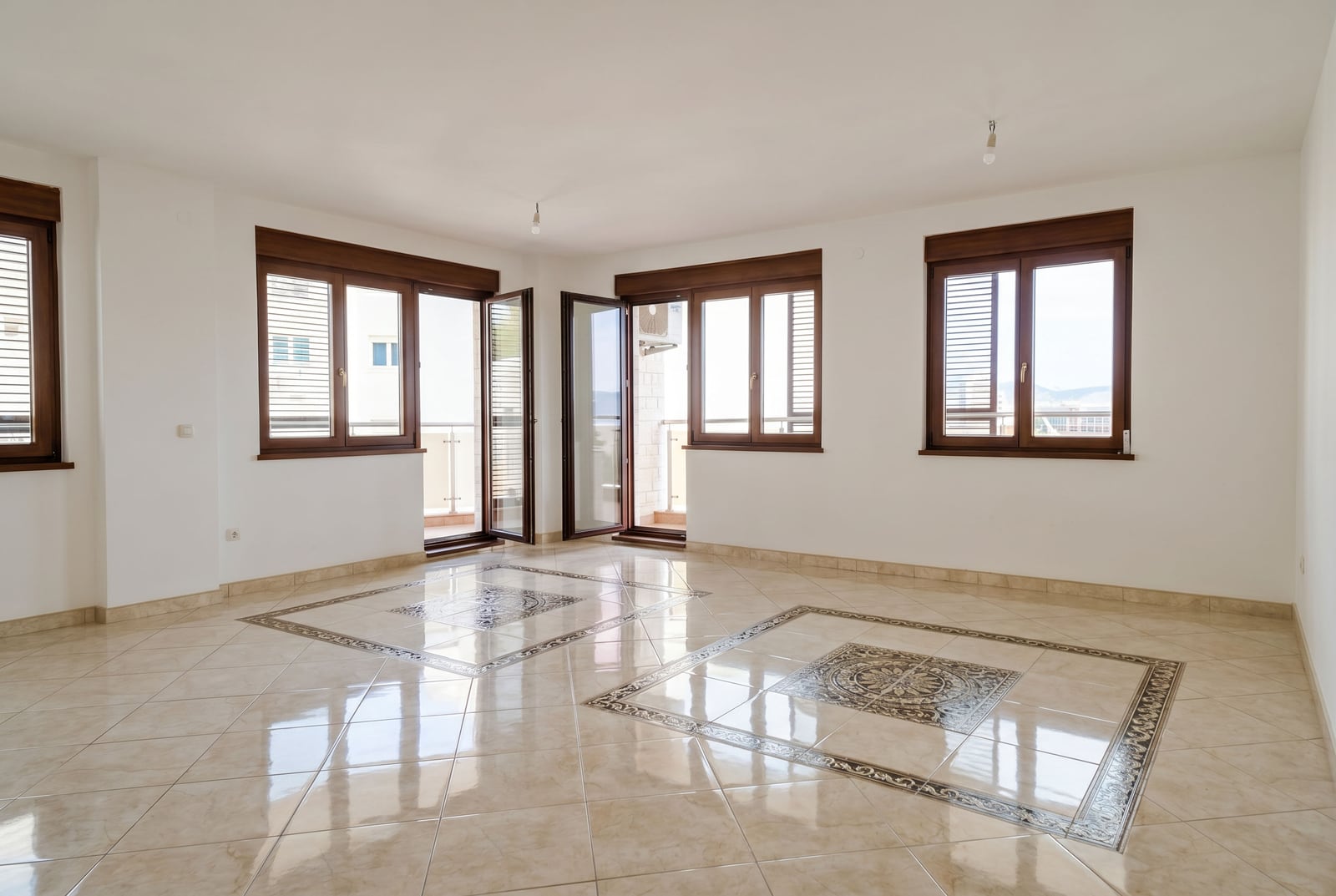 Helles Wohnzimmer mit Fliesenboden und Zugang zum Balkon in einer Wohnung, Bečići, Montenegro.
