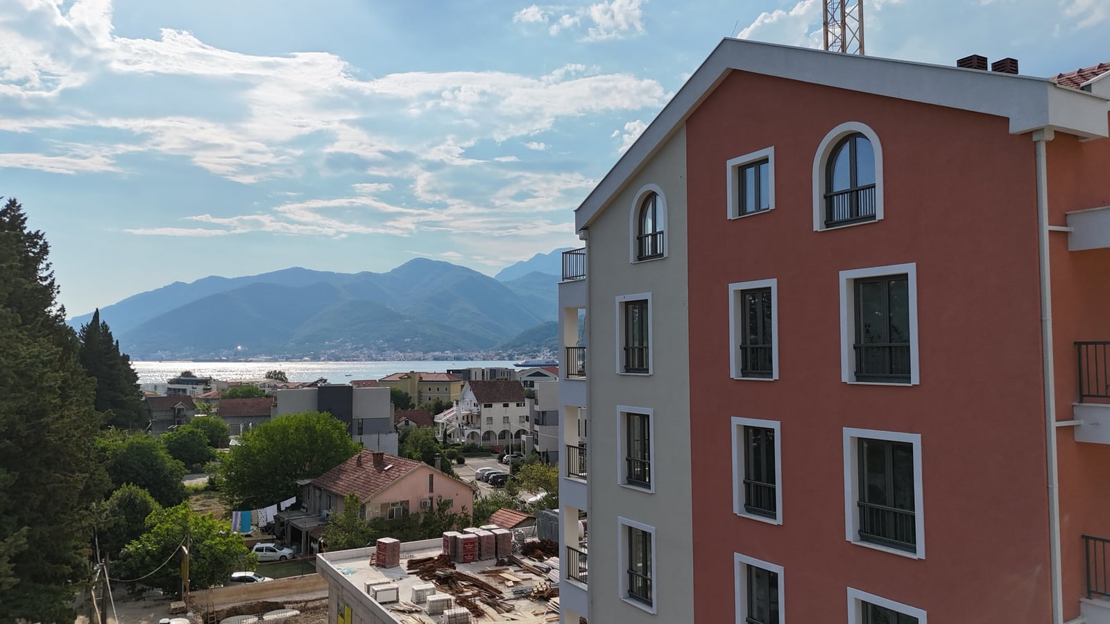 Moderna stambena zgrada u Tivtu, Crna Gora, sa panoramskim pogledom na more i planine iz prozora stana.