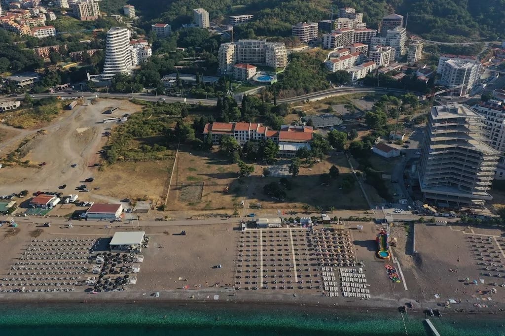 Aerial view of the beach and resort development in Bečići, Montenegro: residential complex by the sea with well-developed infrastructure.