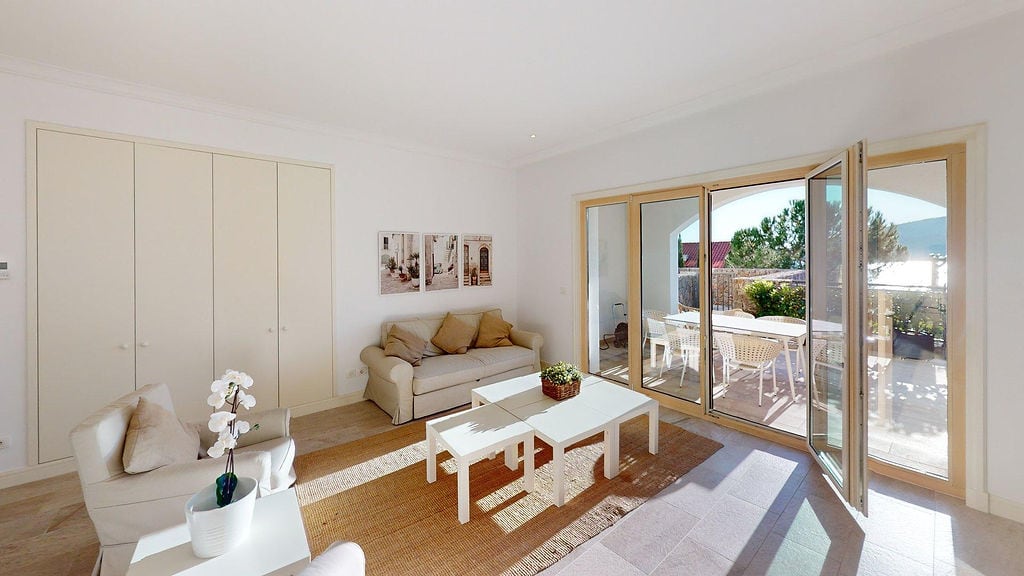 Helles Wohnzimmer in einer Wohnung, Luštica, Montenegro: Polstermöbel, Panoramafenster und Zugang zur Terrasse mit Meerblick.