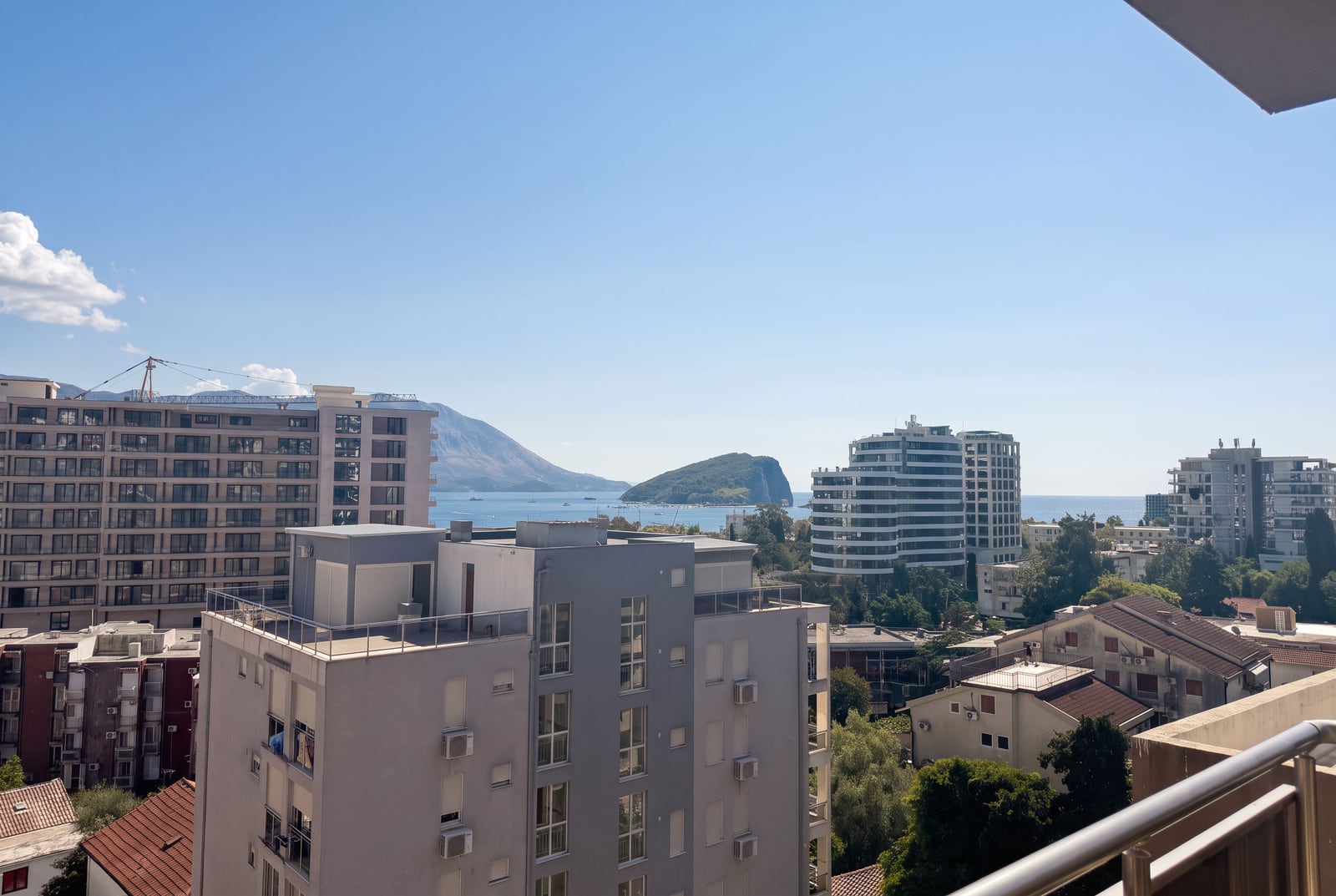 Panoramic view of the sea, mountains, and the city of Budva from the balcony of an apartment in Montenegro