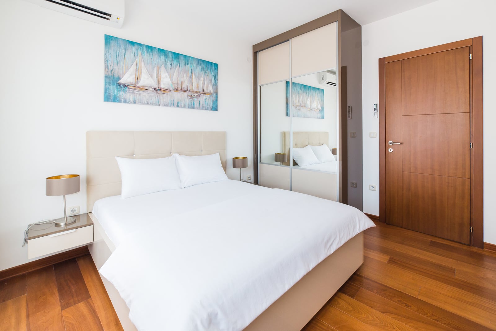 Modernes Schlafzimmer mit Doppelbett und Spiegelschrank in einer Wohnung in Bečići, Montenegro.