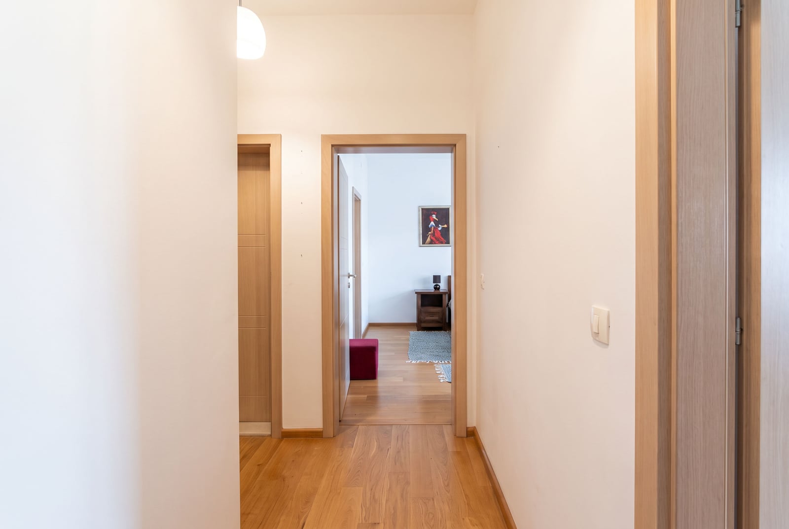 Bright hallway with wooden flooring and interior doors in an apartment in Bečići, Montenegro.