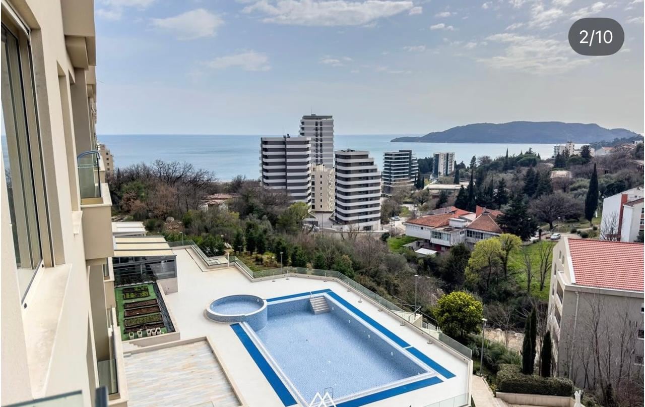 Balcony view of the outdoor swimming pool and the sea in a residential complex, Bečići, Montenegro.