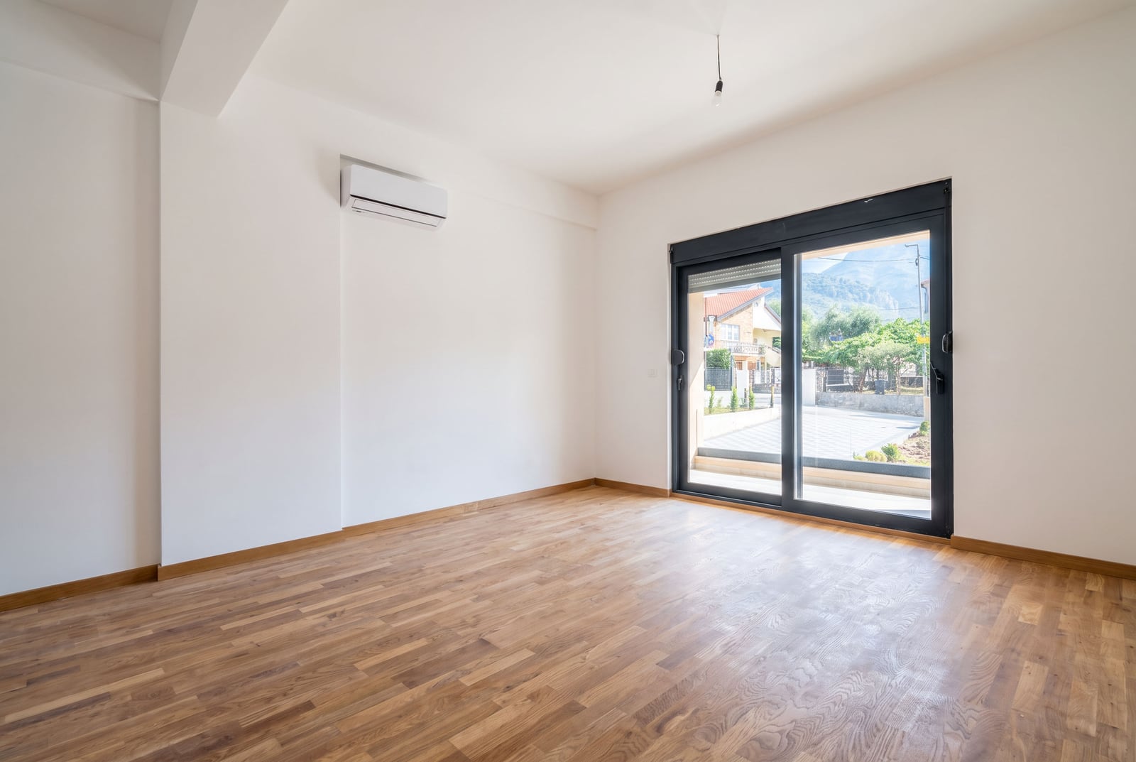 Bright living room with parquet flooring, air conditioning, and panoramic access to the terrace in an apartment, Bar, Montenegro.