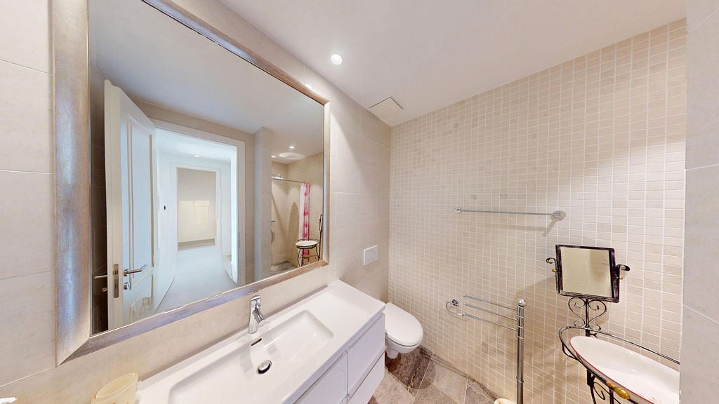 Modern banyo, beyaz sıhhi tesisat ve mozaik fayanslarla, Luštica, Karadağ'daki bir dairede.