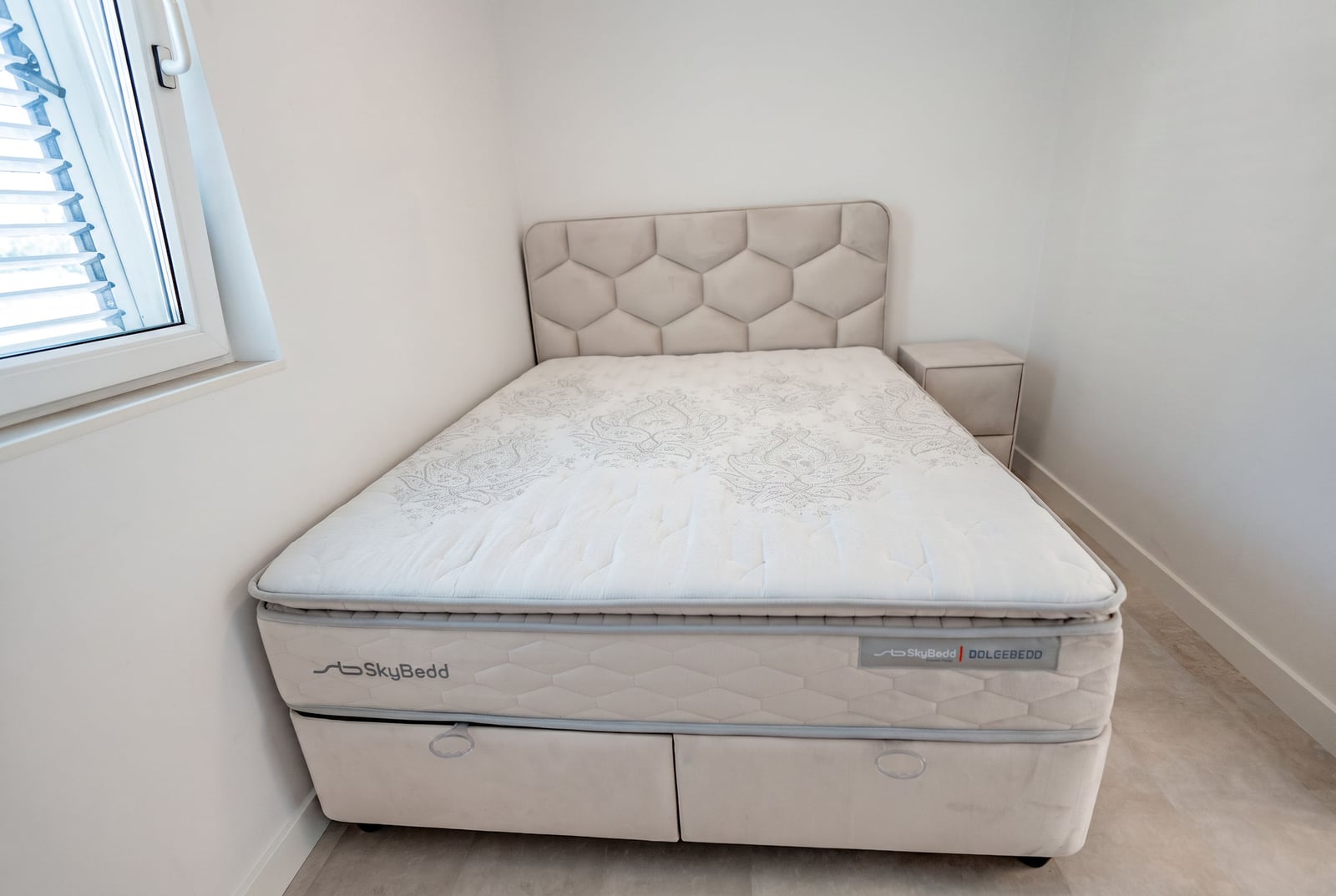 SkyBed double bed with upholstered headboard in a bright bedroom of an apartment in Sveti Stefan, Montenegro.