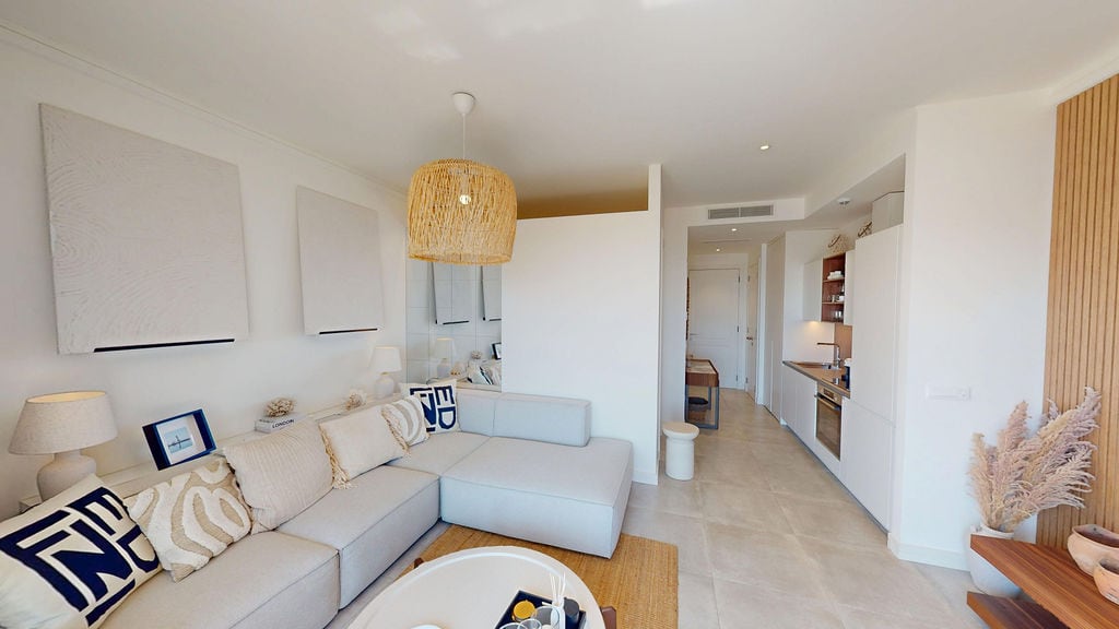 Modernes Wohnzimmer mit Küche in einer Wohnung in Luštica, Montenegro: helles Interieur, bequemes Sofa und stilvolle Dekoration.