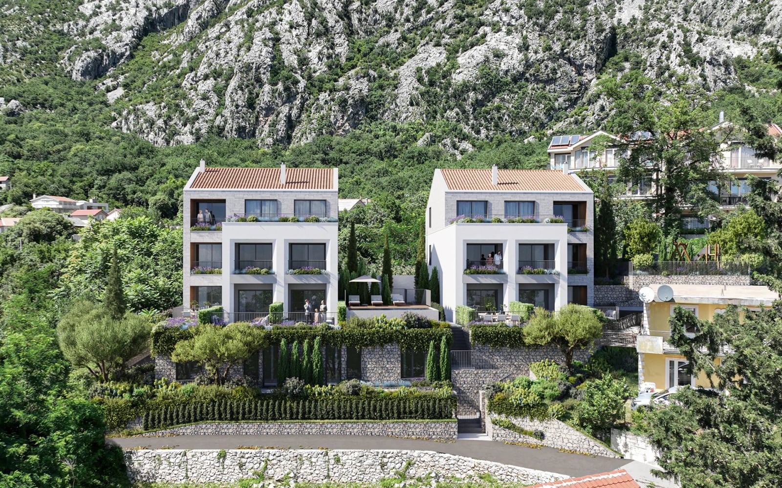 Modern three-story villas with terraces and tiled roofs against a mountain backdrop in Orahovac, Montenegro