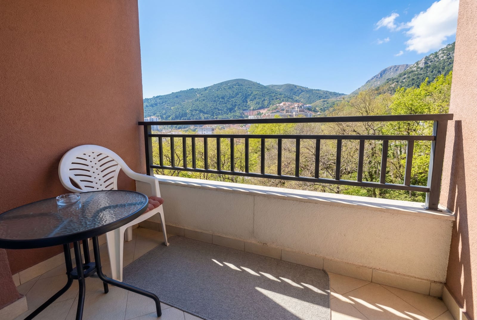 Balkon sa nameštajem i panoramskim pogledom na planine u stanu u Budvi, Crna Gora. Sunčana terasa s pogledom na prirodu.