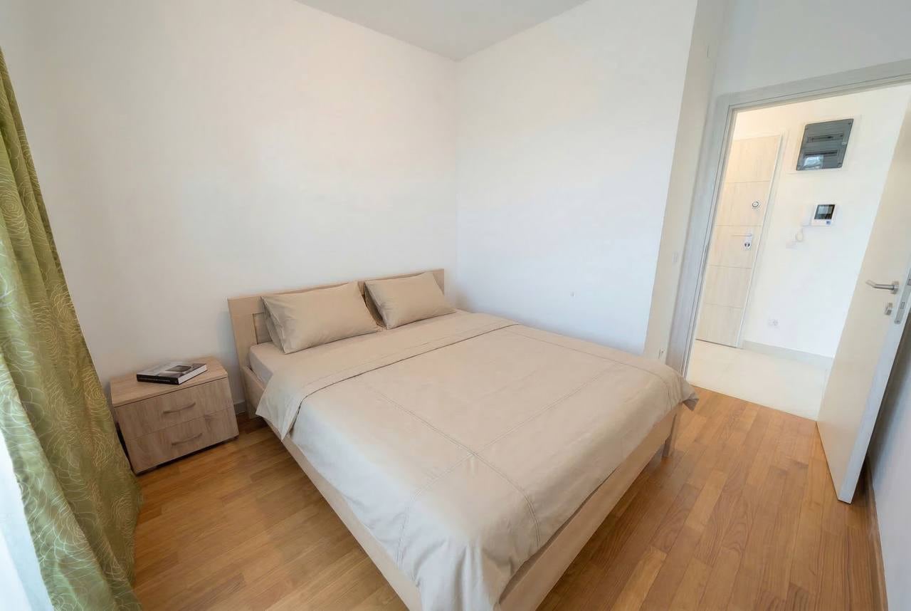 Bright bedroom with a double bed and parquet flooring in an apartment for sale, Bečići, Montenegro.