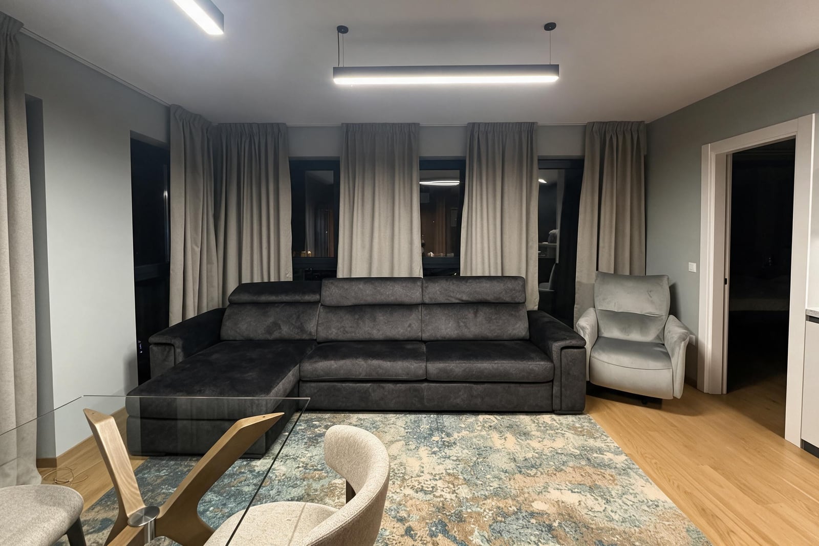 Modern living room with a large gray sofa and armchair in an apartment in Budva, Montenegro