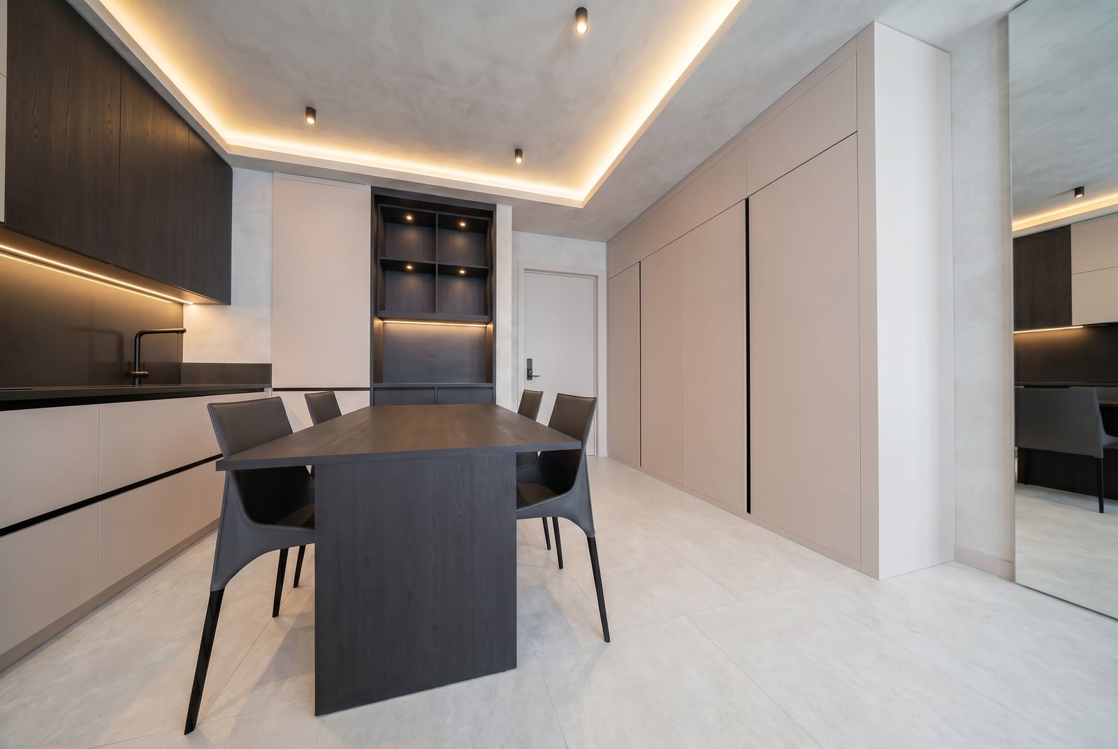 Moderne Küche in einer Wohnung in Tivat, Montenegro: dunkle Möbel, Essbereich und Einbauschränke mit Beleuchtung.