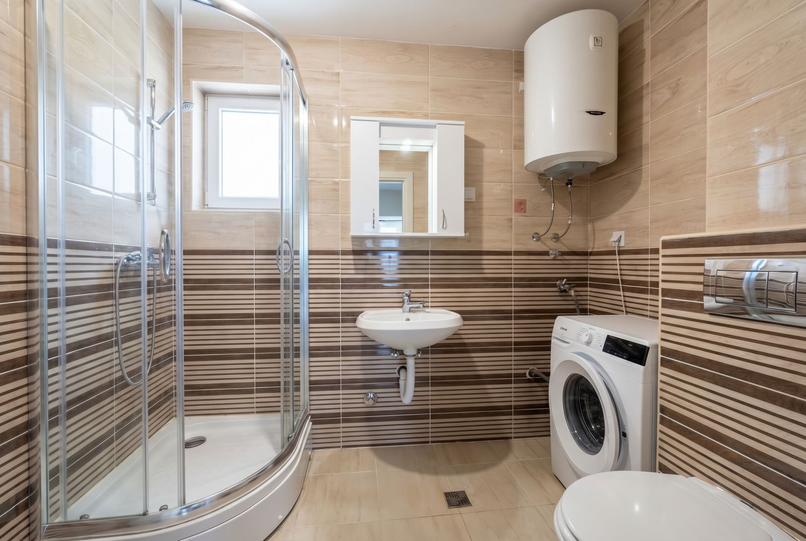 Budva, Karadağ’daki dairede banyo: duş kabini, çamaşır makinesi, бойлер ve fayans kaplama.
