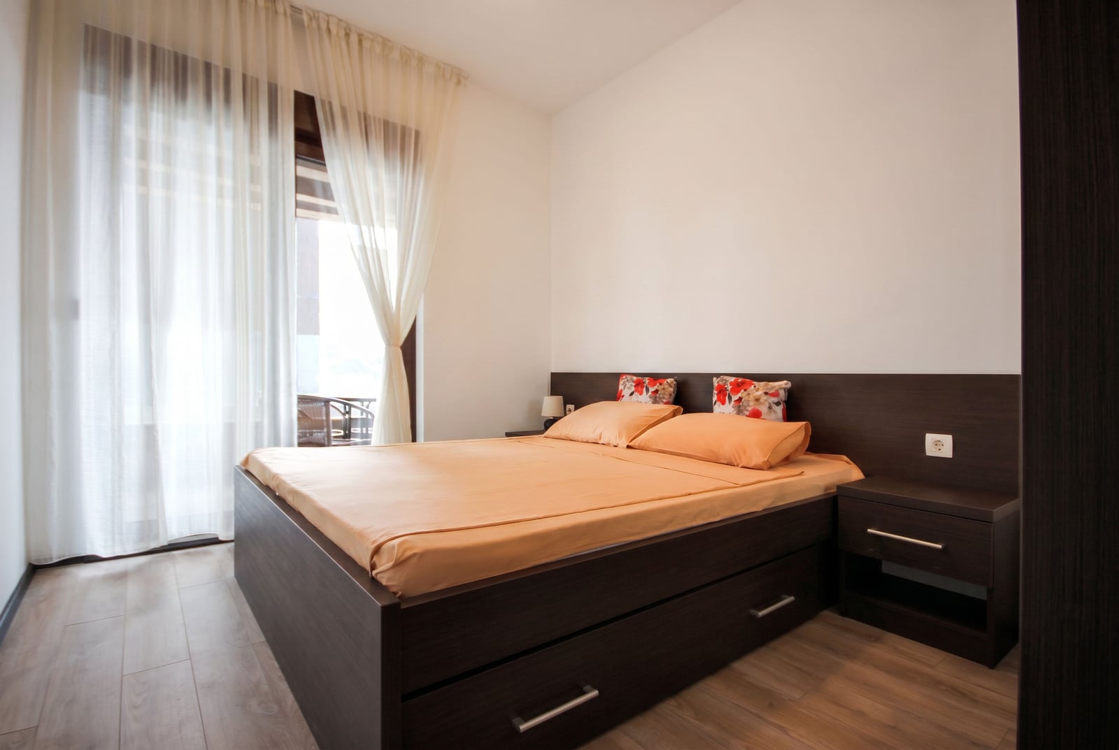 Cozy bedroom with a double bed in a Budva, Montenegro apartment, featuring a bright interior and balcony access.