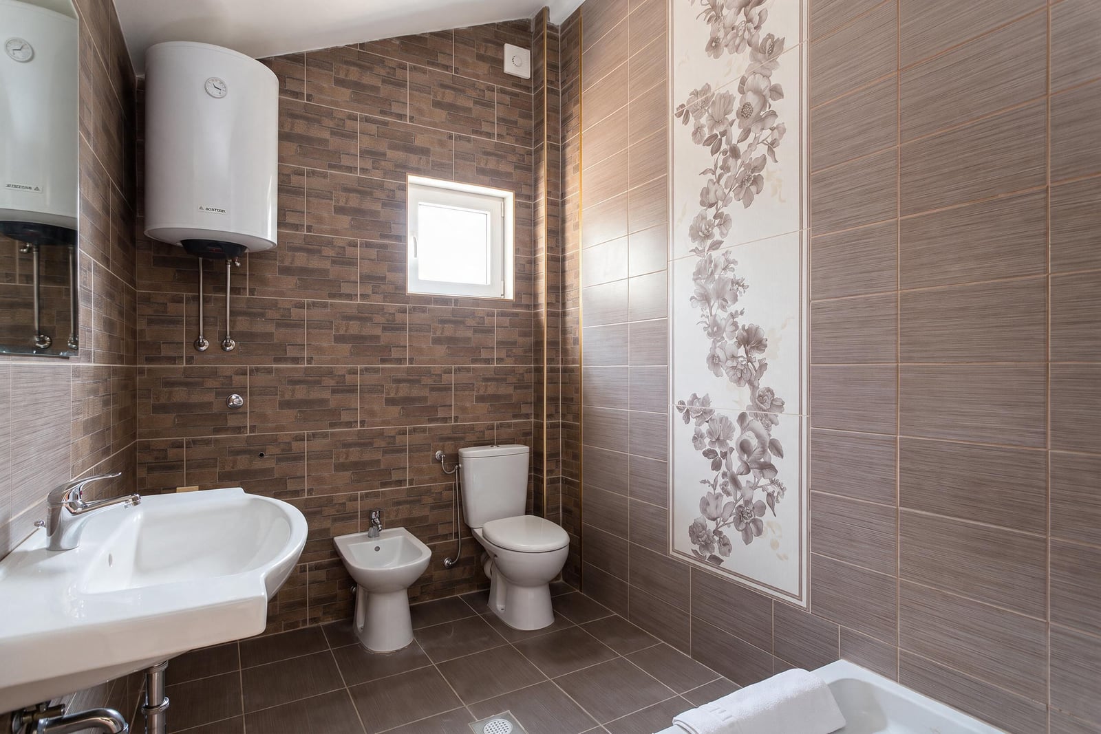 Modern bathroom with water heater, sink, and toilet in a house in Tivat, Montenegro