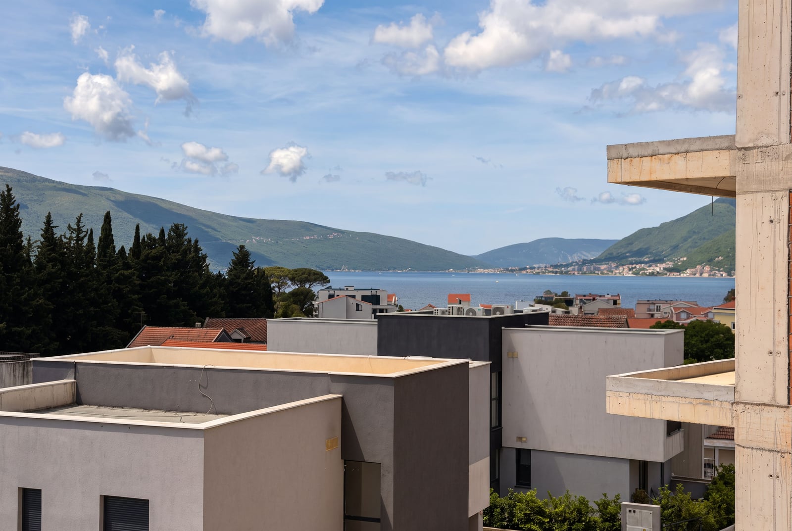 Panoramic view of the sea, bay, and mountains from the balcony of a building under construction in Tivat, Montenegro.