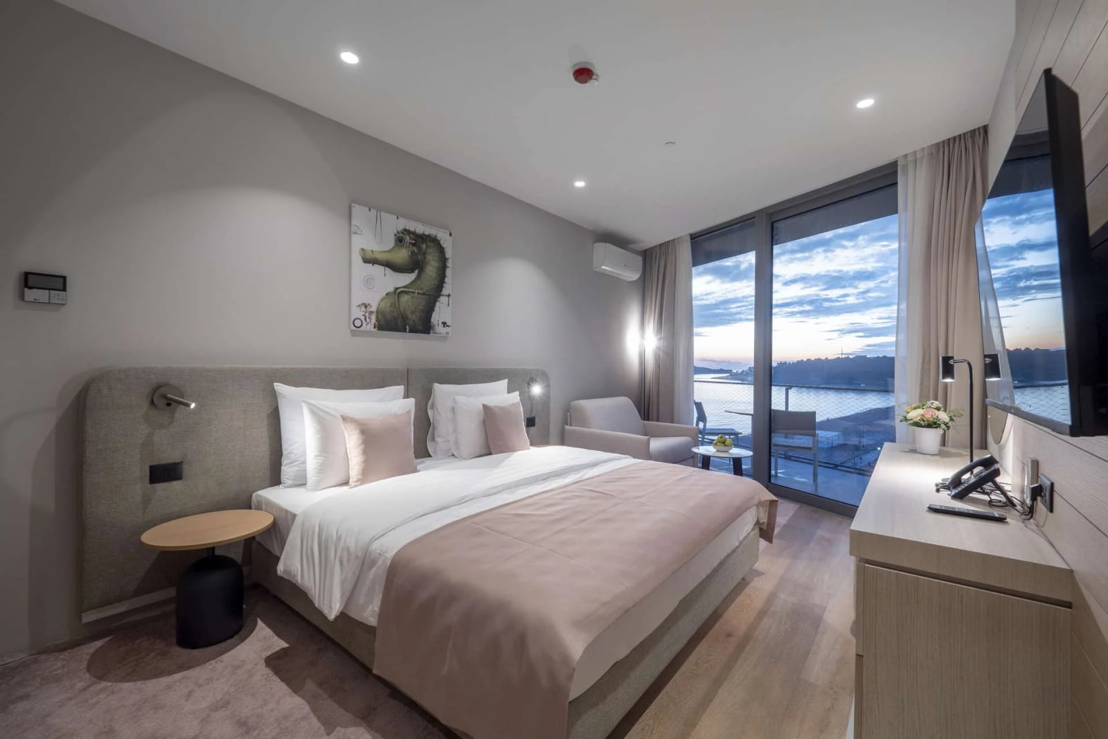 Moderna spavaća soba sa panoramskim prozorom i pogledom na more u hotelu odmarališta Bečići, Crna Gora