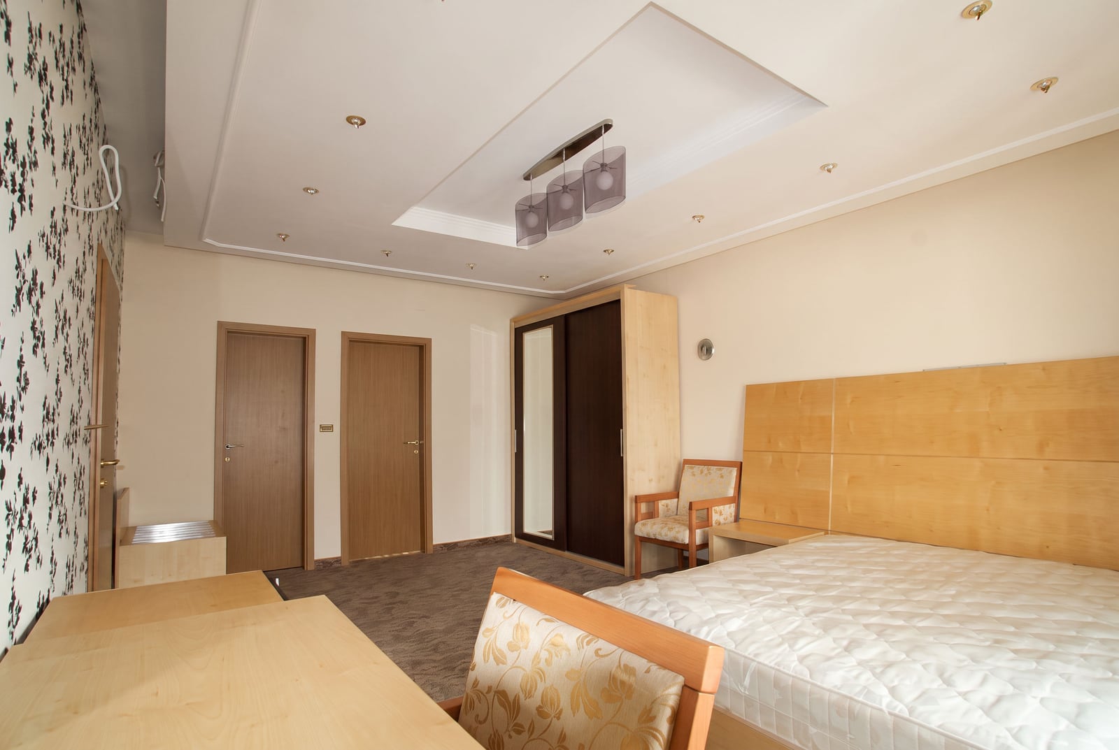 Spacious bedroom with wooden furniture, a double bed, and a wardrobe in a house in Tivat, Montenegro.