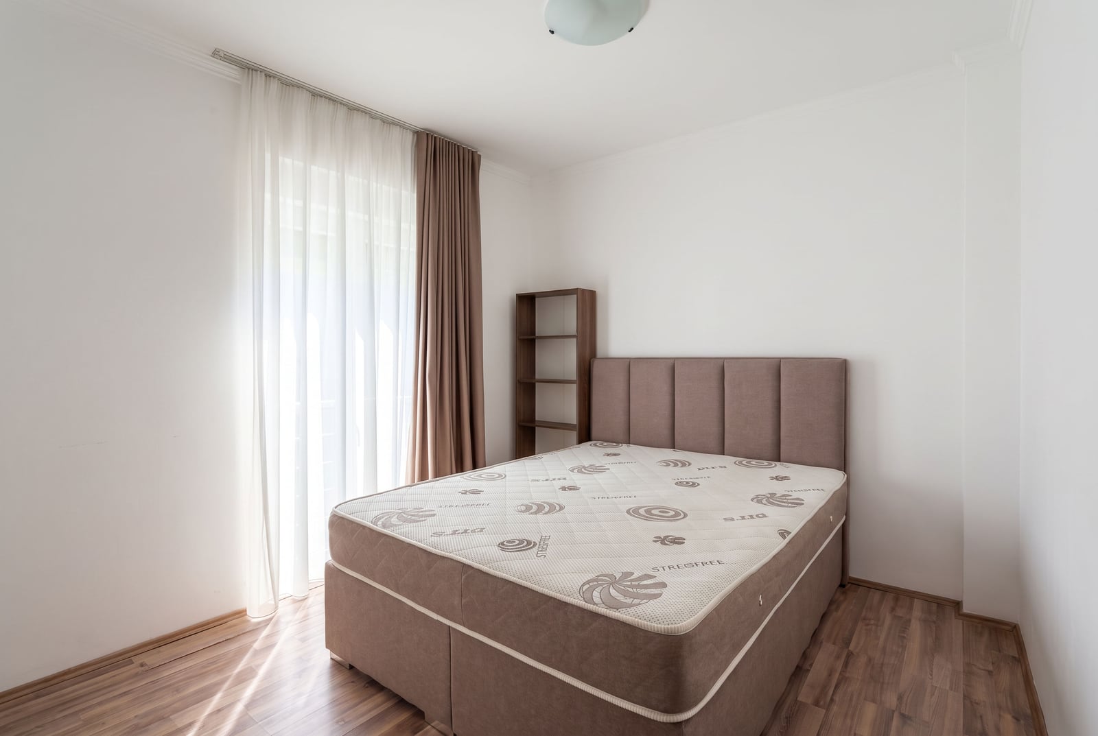 Svetla spavaća soba sa bračnim krevetom i izlazom na balkon u stanu u Tivtu, Crna Gora