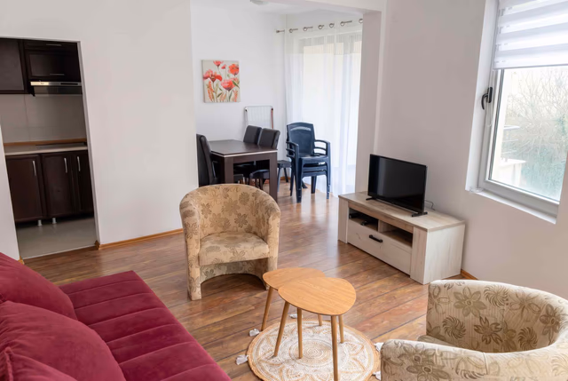 Wohnzimmer mit Polstermöbeln und Essbereich in einer Wohnung in Bečići, Montenegro: modernes Interieur mit TV-Bereich.
