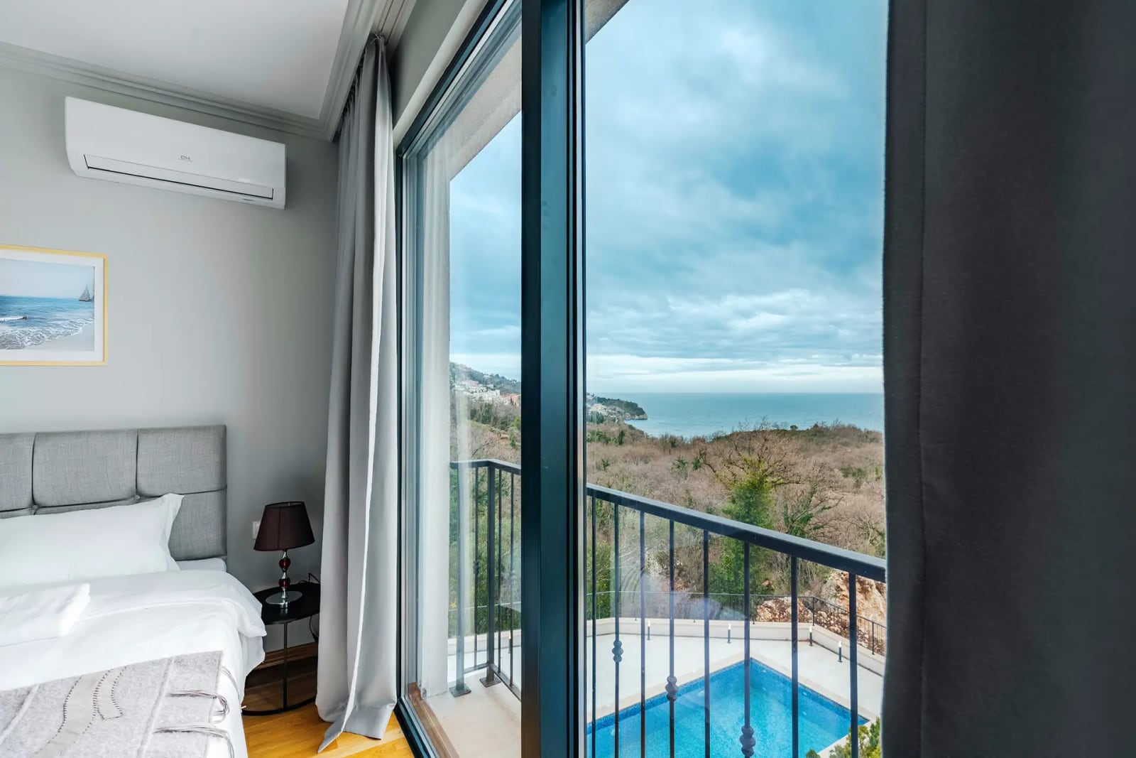 Bedroom in a villa in Reževići, Montenegro: panoramic sea view, swimming pool, and balcony with modern finishes.