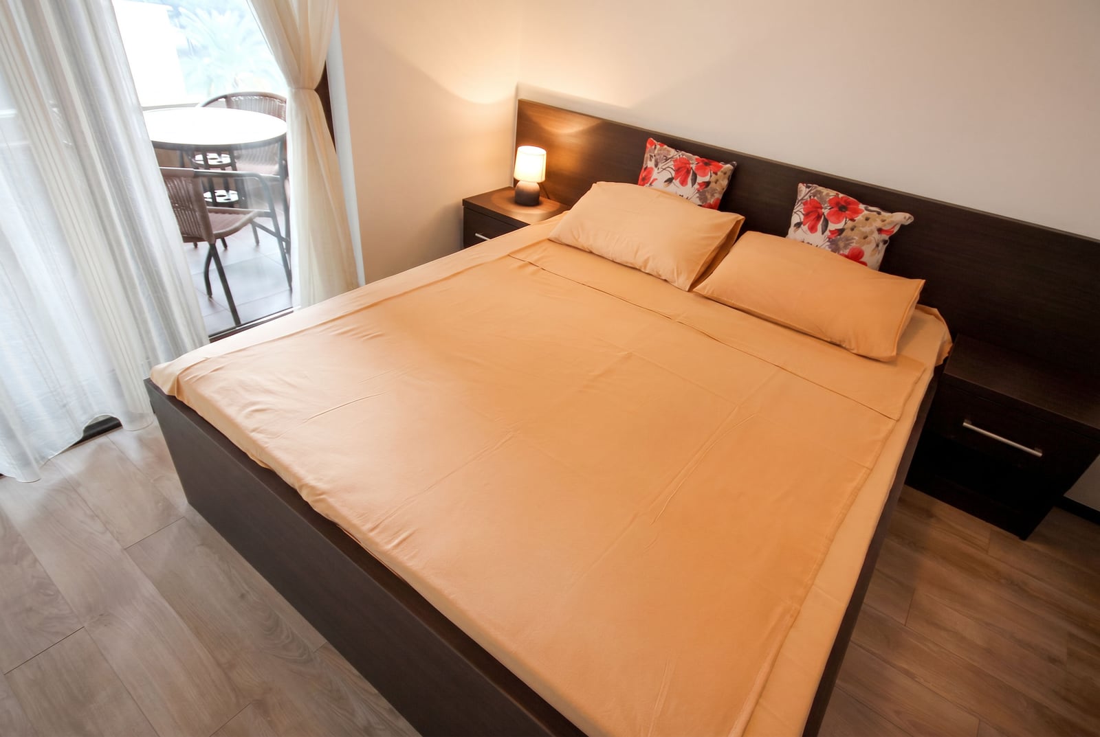 Cozy bedroom with a double bed and balcony access in an apartment in Budva, Montenegro. Modern interior.