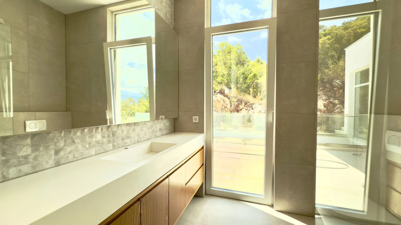 Modernes Badezimmer mit Panoramafenstern und Terrasse in einer Villa in Krašići, Montenegro. Hochwertige Ausstattung.