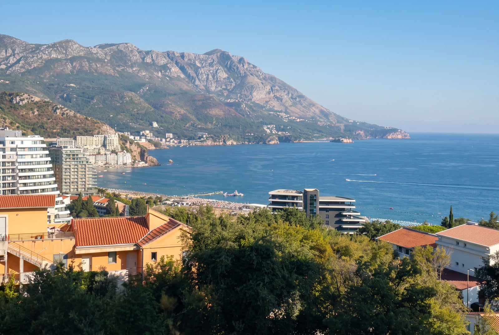 Panoramic aerial view of the sea, mountains, and the resort town of Becici in Montenegro