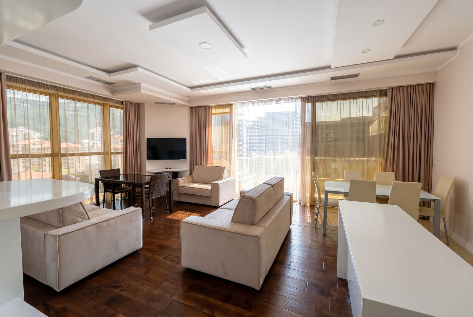 Bright living room with upholstered furniture and panoramic windows in an apartment in Budva, Montenegro. Modern interior.