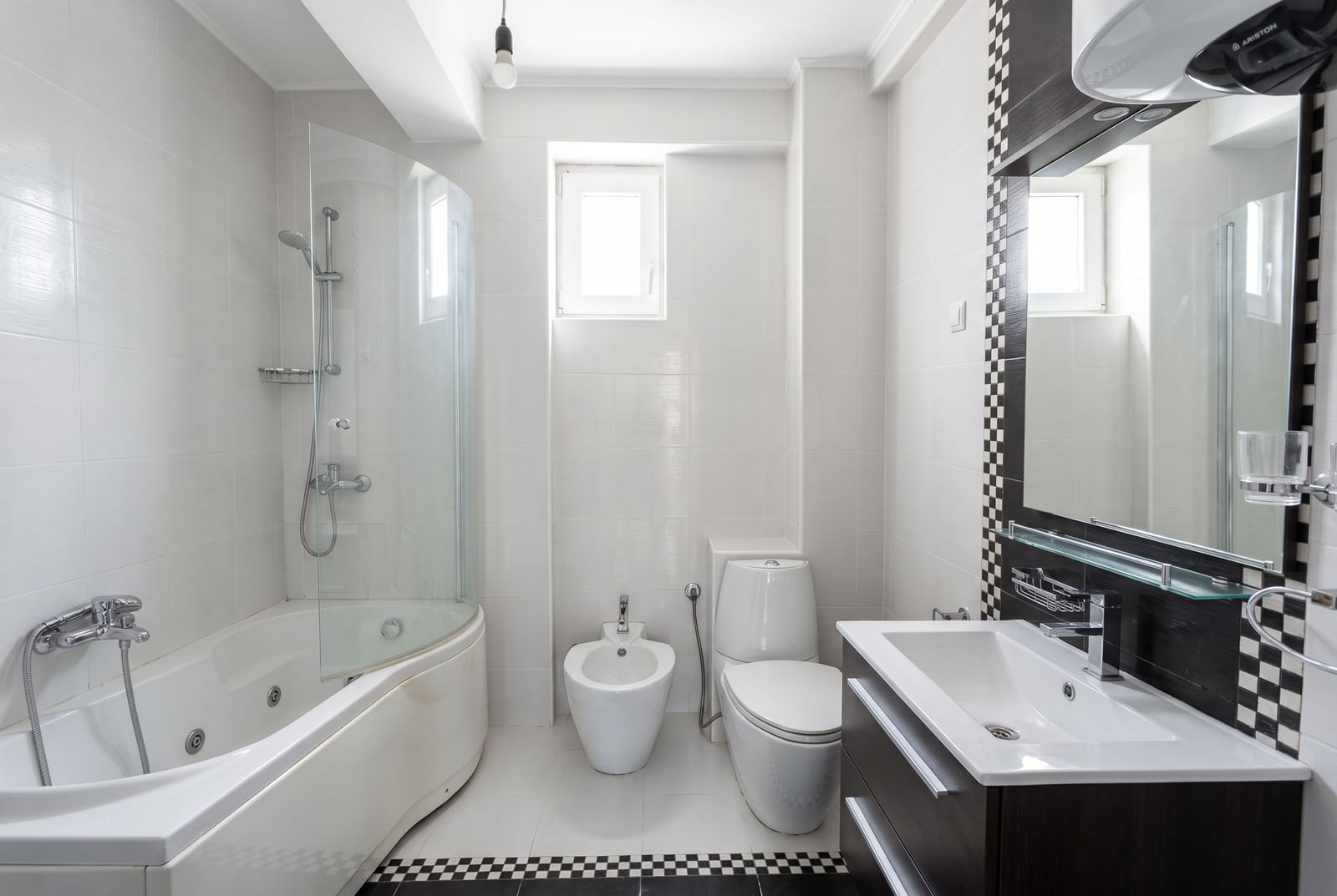 Modern bathroom with a corner bathtub, shower screen, sink, and bidet in an apartment in Petrovac, Montenegro.