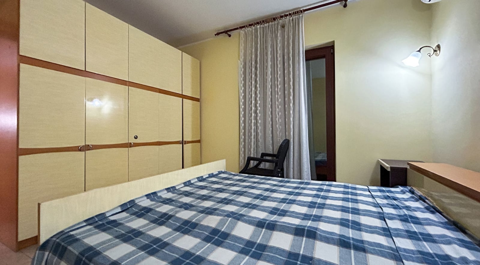 Schlafzimmer in einer Villa in Dobrota, Montenegro: Doppelbett, großer Einbauschrank und Zugang zum Balkon.