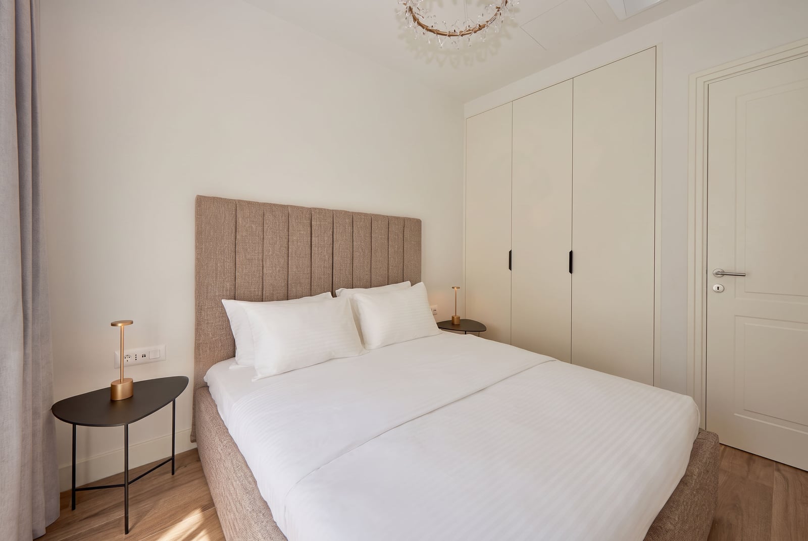 Modernes Schlafzimmer mit Doppelbett, weißem Schrank und Nachttischen in einer Wohnung in Luštica, Montenegro