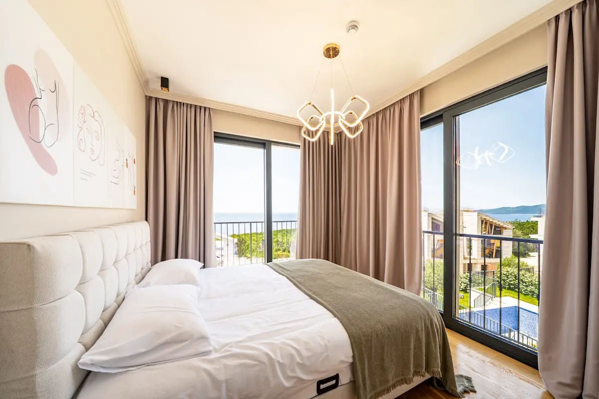 Chambre moderne avec baies vitrées et vue sur la mer dans une villa à Reževići, Monténégro.