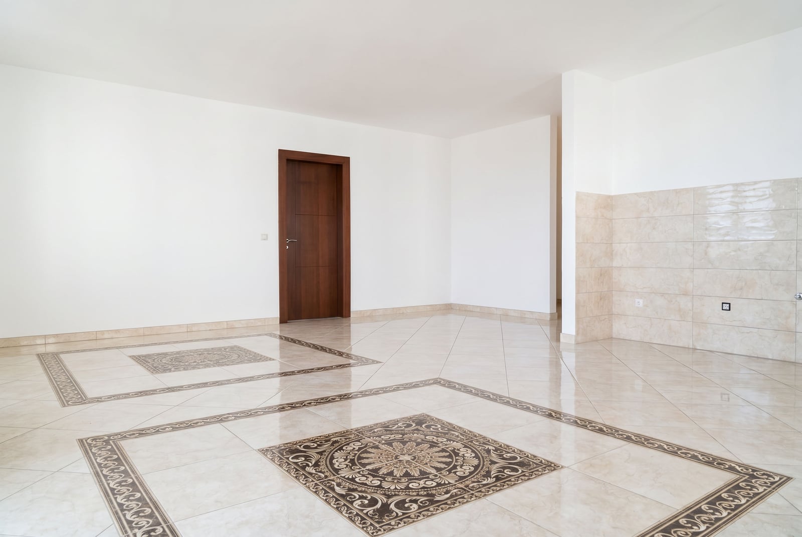 Geräumiges, helles Wohnzimmer in einem Apartment in Bečići, Montenegro: Boden mit dekorativen Fliesen und eine dunkle Zimmertür.