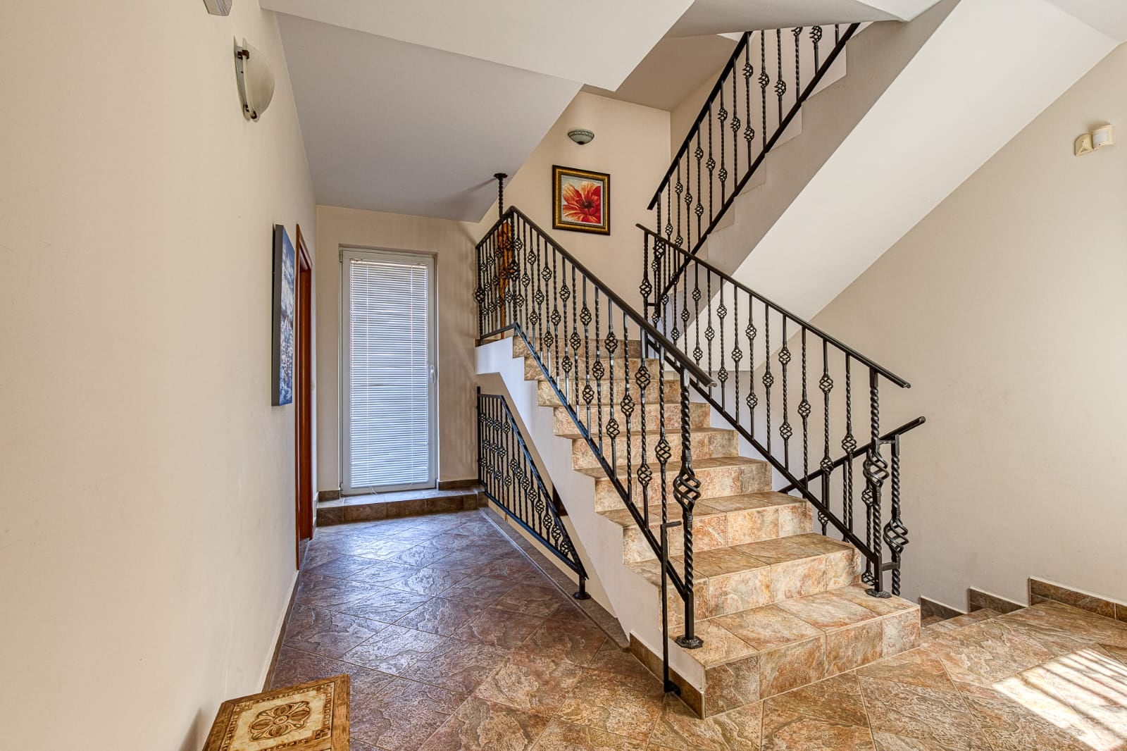 Escalier avec rampe en fer forgé et finitions en carrelage dans l'intérieur d'une villa à Bečići, Monténégro.