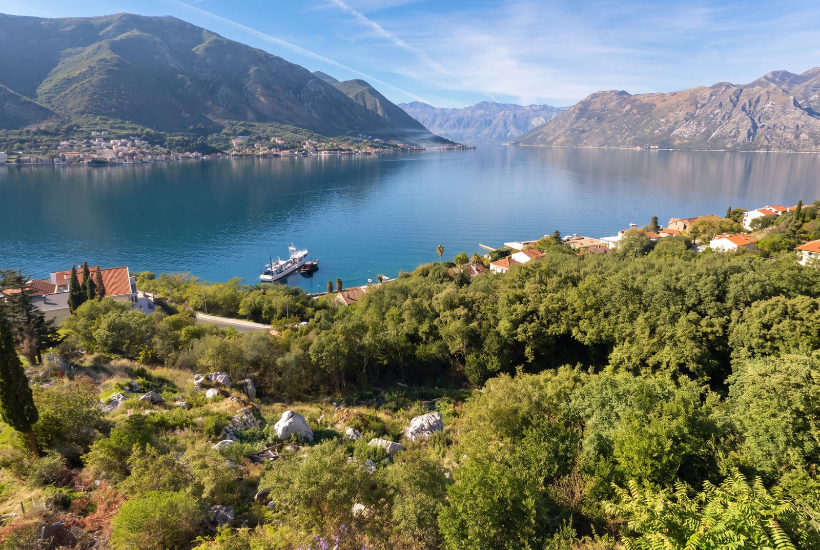 Panoramski pogled na Boku Kotorsku, planine i zelenu padinu u naselju Dobrota, Crna Gora