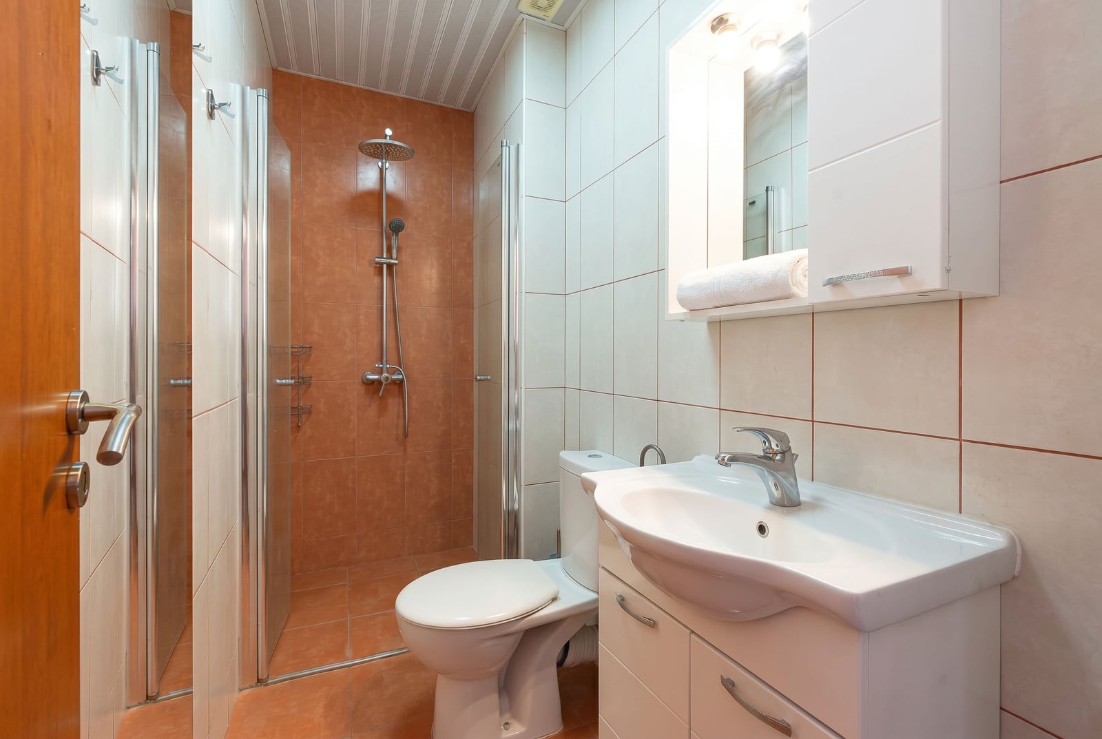 Salle de bain avec cabine de douche et mobilier clair dans une villa, Bečići, Monténégro. Finitions modernes en carrelage.